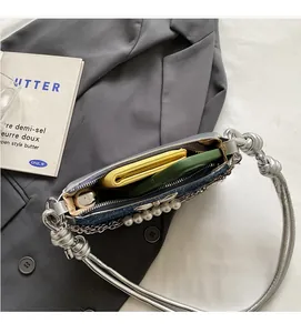 Interior view of denim shoulder bag showing brown lining, zipper pocket, and storage space