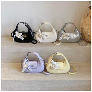 Group of colorful pleated hobo bags on stone steps with pearl heart charms and lace bows