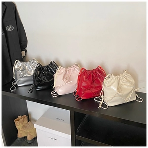 Collection of silver, black, and pink patent leather bucket bags with bow detailing