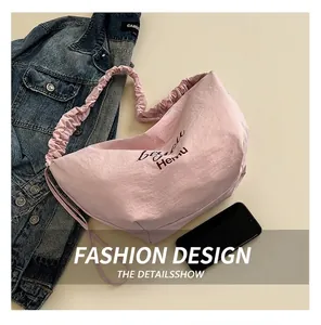Detailed close-up of pink pleated nylon tote bag with artistic Hemu logo print
