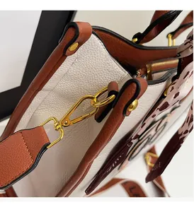 Detail of white lychee grain tote with gold buckle and leopard print scarf accessory