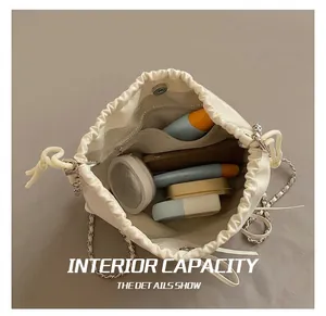 Interior view of white leather bucket bag showing capacity for phone and cosmetics