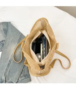 Vue de haut du sac cabas tressé montrant sa grande capacité et sa pochette zippée