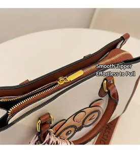 Detail of smooth metal zipper and cute bear print on white and brown tote bag