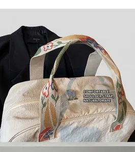 Detail showing high-capacity nylon bag with colorful floral woven wide shoulder strap