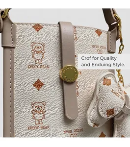 Detail of white PU shoulder bag with bear patterns, leather piping and gold buckle