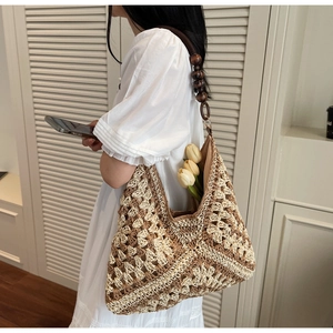 Close-up of hand-woven straw tote with bicolor pattern and ethnic wooden bead strap