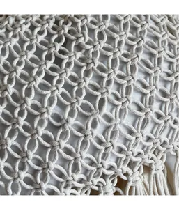 Close-up of bohemian hollow weave pattern and long fringe tassels on a beach tote bag