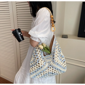 Detail of hand-woven crochet tote bag with floral pattern and wooden bead handle