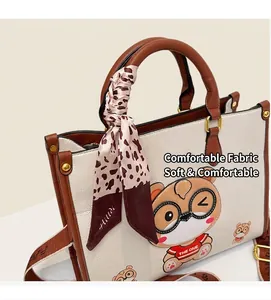 Detail of a large tote bag with bear print, leopard silk scarf and brown shoulder strap