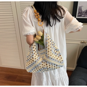 Detail of hand-woven geometric pattern bag with natural wooden bead shoulder strap