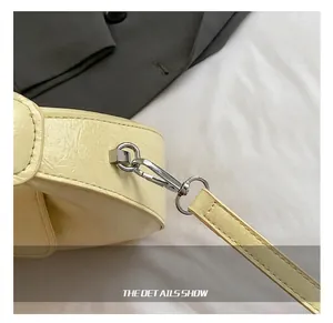 Detailed close-up of premium silver metal swivel hook and pleated cream leather strap