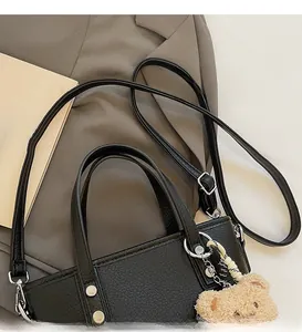 Detail of adjustable shoulder strap and silver metal buckle on black bucket bag