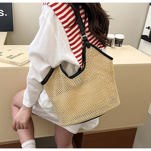 Détail de la texture en maille ajourée et de la bandoulière en cuir noir du sac cabas