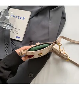 Detail view of beige monogram mini bag interior holding a smartphone with gold chain