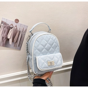 Detail of light blue quilted mini backpack with silver chain strap and metal swivel lock