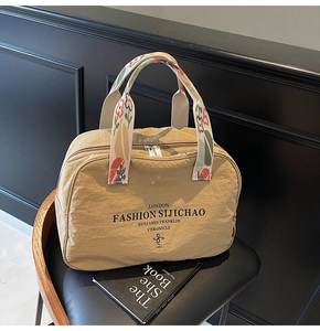 Detail of floral embroidered handle and London print on beige nylon travel tote bag