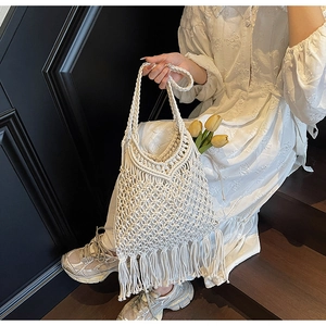 Detail of bohemian woven tassel tote bag featuring wheat pattern stitching and fringe trim