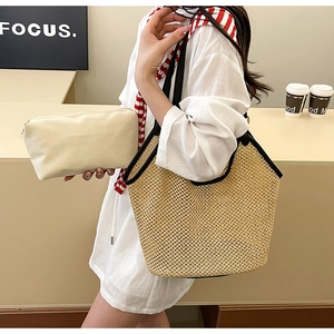Détail du sac seau en paille avec anse en cuir et pochette de rangement en toile