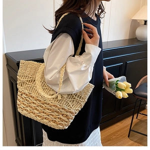 Detailed close-up of handmade woven straw tote bag with intricate hollow mesh pattern