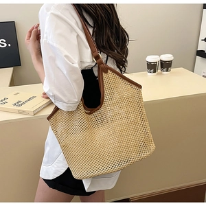 Grand sac cabas en paille tressée avec lanières en cuir marron porté par un mannequin