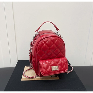 Detail of red quilted patent leather bag showing silver twist lock and chain strap