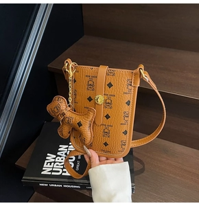Caramel brown pebbled leather crossbody bag with cartoon bear print and dog charm