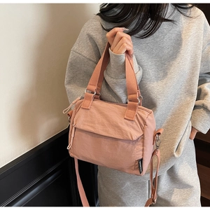 Détail de la texture en toile de nylon rose et de l'étiquette de marque sur la sacoche