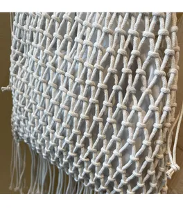 Detailed macro view showing woven cotton rope texture and long tassel fringe of the bucket bag