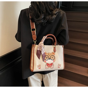 Detail of cute bear tote bag with floral ribbon and wide lettered shoulder strap