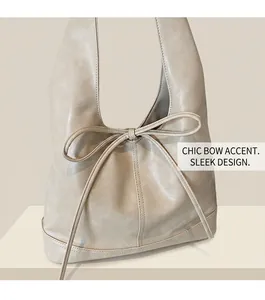 Détail d'un sac à bandoulière beige crème en similicuir avec un nœud décoratif souple