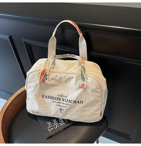 Close-up of cream nylon tote bag with floral print straps and elegant brand logo