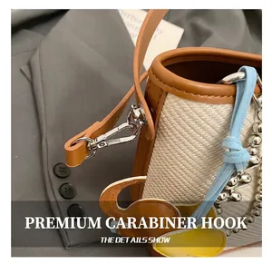 Detail of premium silver swivel hook on woven bucket bag with brown leather trim