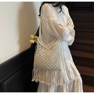 Detail of bohemian handmade woven white cotton shoulder bag with long fringe tassels