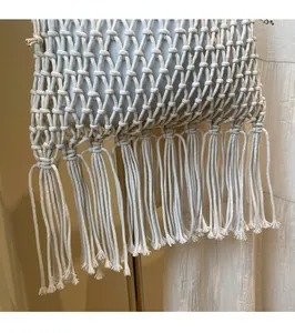 Close-up of cream handmade woven tote bag featuring hollow knit patterns and long fringes