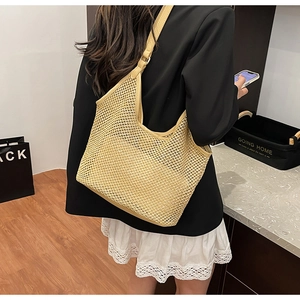 Détail du sac cabas en paille tissé à la main avec bandoulière en cuir réglable