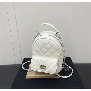 Close-up of white quilted mini backpack with silver metal turn-lock and chain straps