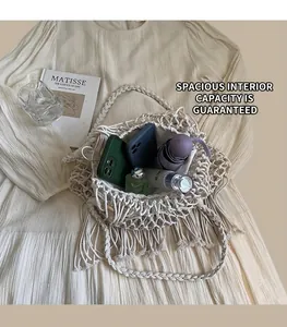 Interior view showing the large capacity and macramé tassels of this white woven bucket bag