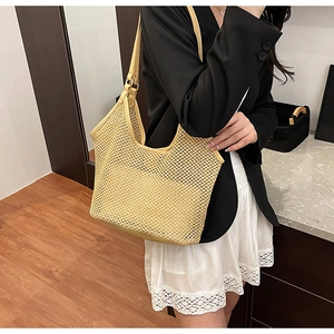 Détail du sac cabas en paille tissée jaune montrant le design en maille ajourée