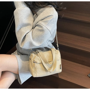 Sac bandoulière en toile kaki avec poignées larges et bandoulière sur le modèle