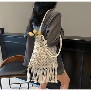 Detail of bohemian macramé tote bag featuring woven texture and long fringe tassels