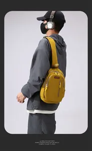 Macro shot of ginger yellow crossbody bag with multi-zip compartments and red logo