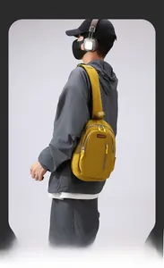 Macro shot of ginger yellow crossbody bag with multi-zip compartments and red logo