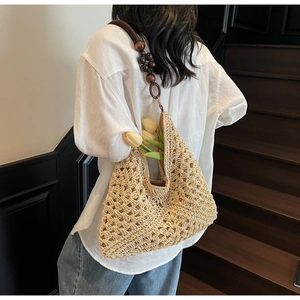 Detail of hand-woven straw hobo bag with vintage dark brown wooden bead shoulder strap