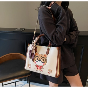 Detail showing high-capacity white bear tote bag with brown handles and patterned silk scarf