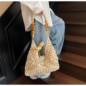 Detail of hand-woven beige crochet tote bag with unique vintage wooden bead handle