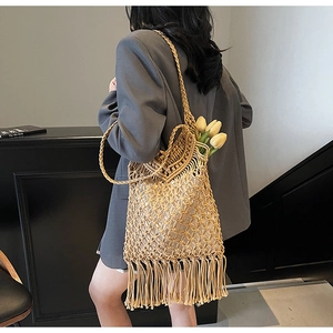 Detail view of beige macrame woven tote bag featuring hollow texture and long fringe