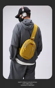 Detail of yellow crossbody chest bag featuring waterproof nylon texture and zip pockets