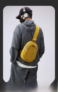 Detail of yellow crossbody chest bag featuring waterproof nylon texture and zip pockets