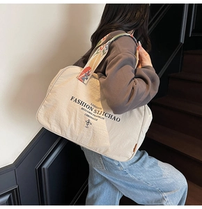 Detail of colorful ethnic woven strap on beige nylon tote bag with London fashion print